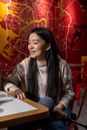 Young Asian actress filming in cafe