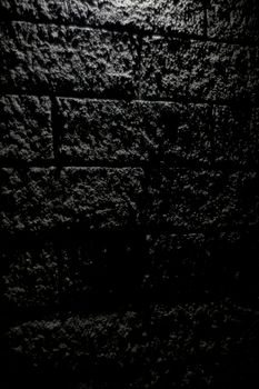 Detailed shot of a textured concrete wall with dramatic lighting.