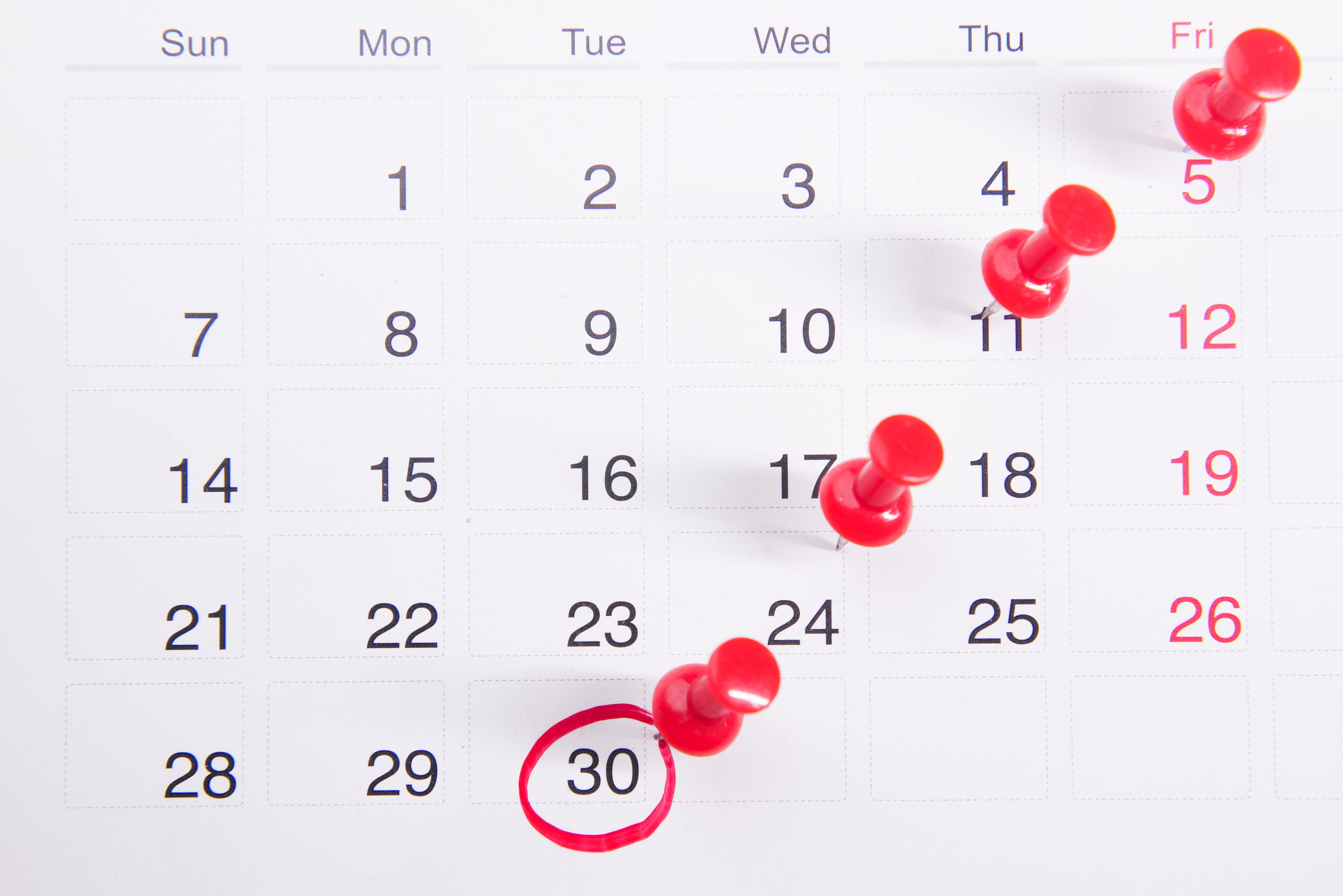 Calendar marked with red pushpins on several dates, with the 30th circled in red