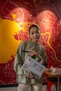 Young actress in cafe holding clapperboard