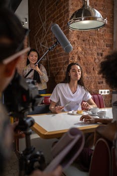 Actors and crew recording a scene in a cozy cafe setting, showcasing film production details.