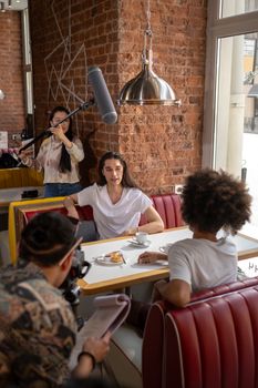 A candid interview setup in a stylish cafe, featuring a diverse group of young adults.