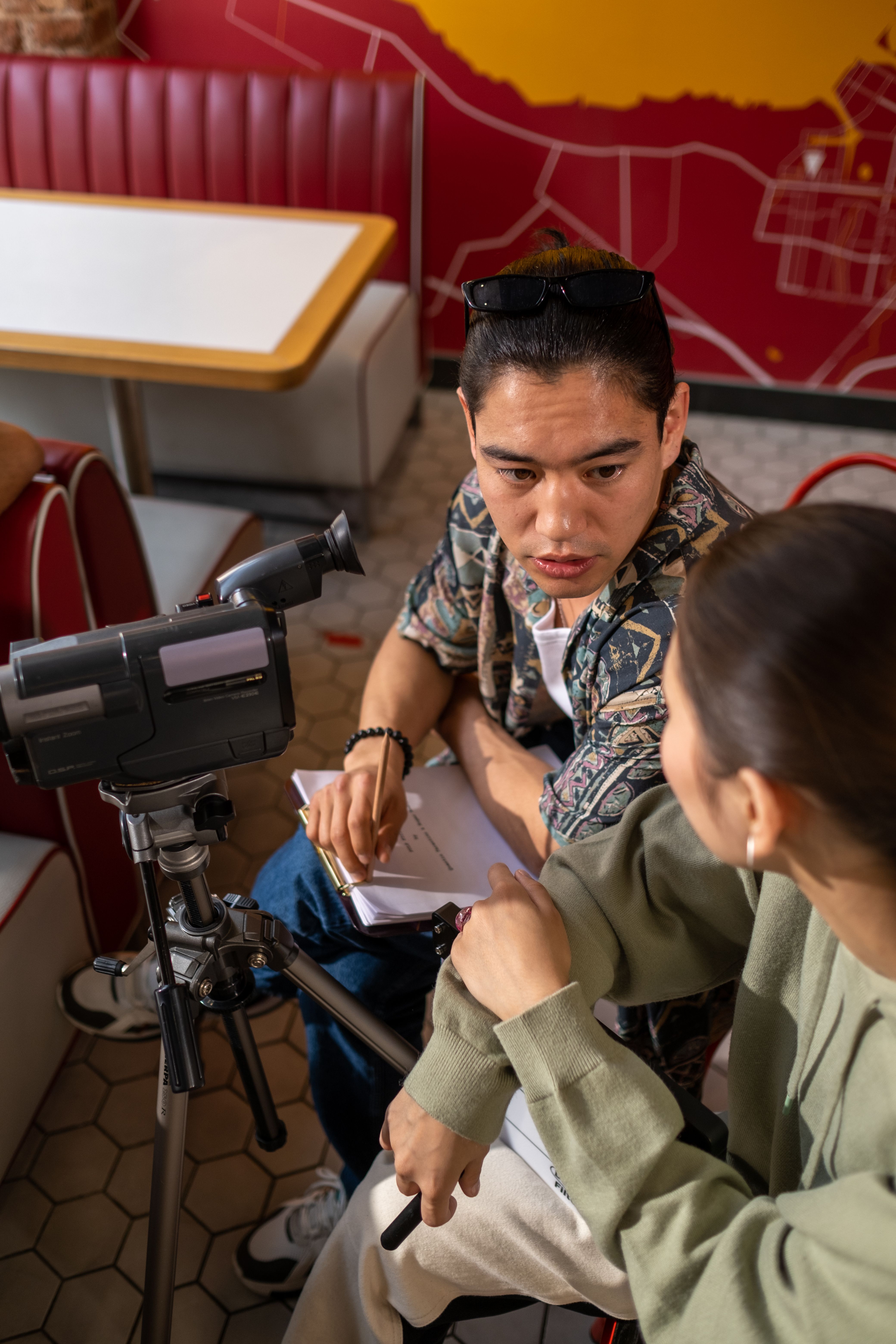 Candid shot of a director in discussion with a cameraman indoors. Creative collaboration.