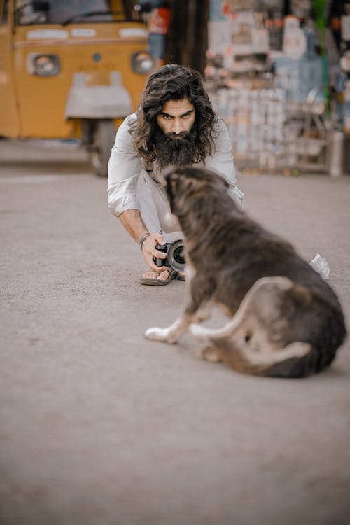 Photograph of a Man Taking a Photo of a Dog