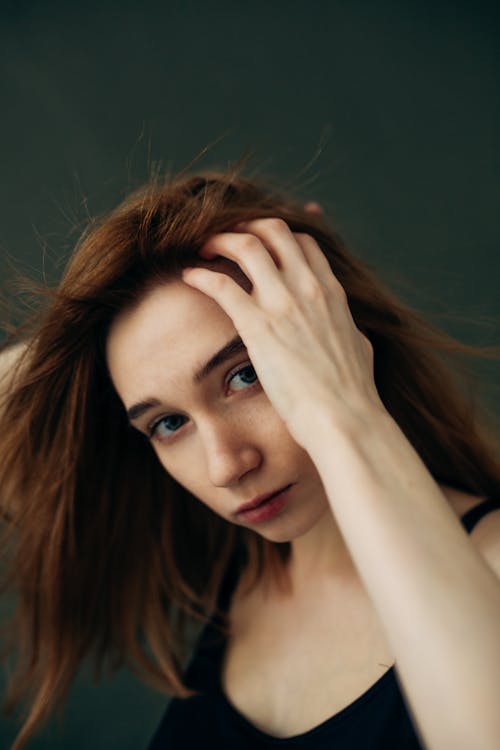 Portrait of brown hair woman with hand in hair