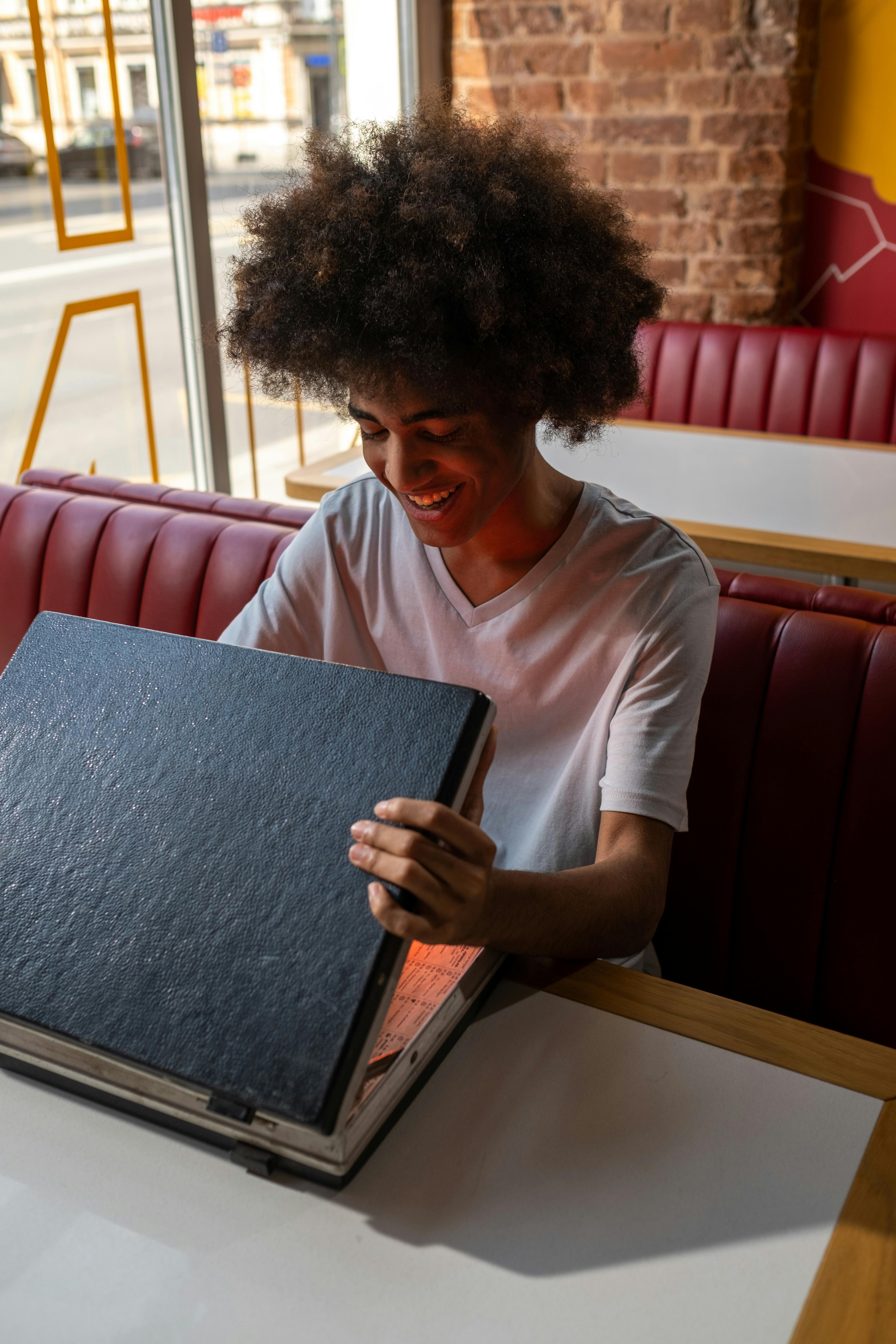 a black man opening a case in a cafe