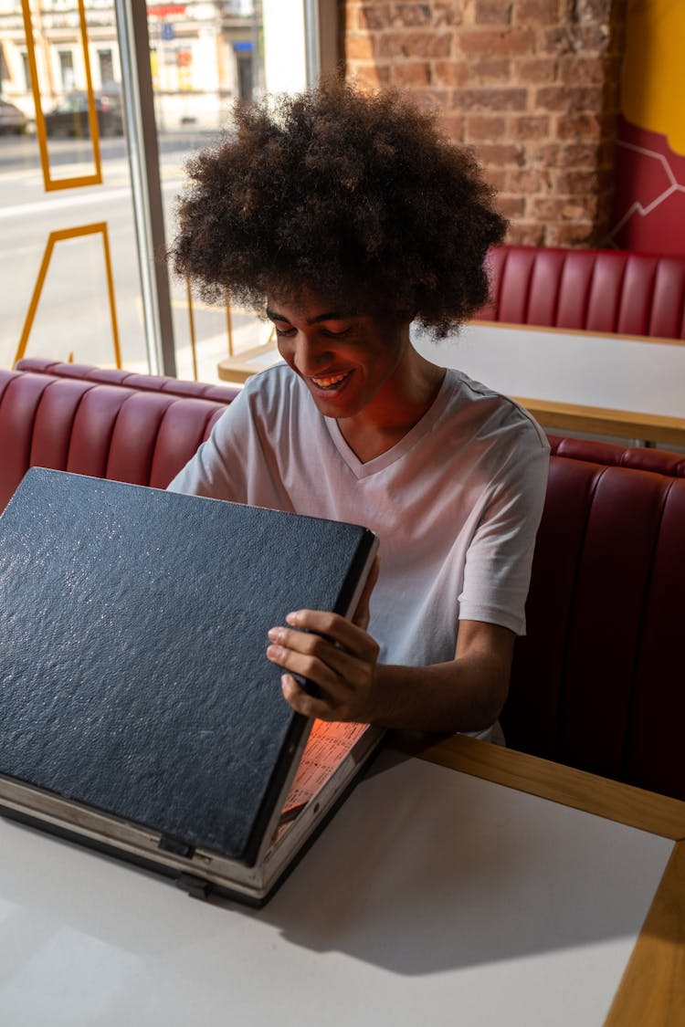 A Black Man Opening A Case In A Cafe