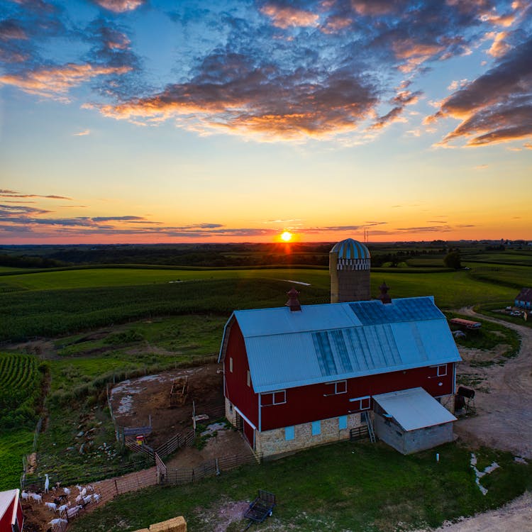 A Barn In The Farm Field During Sunset