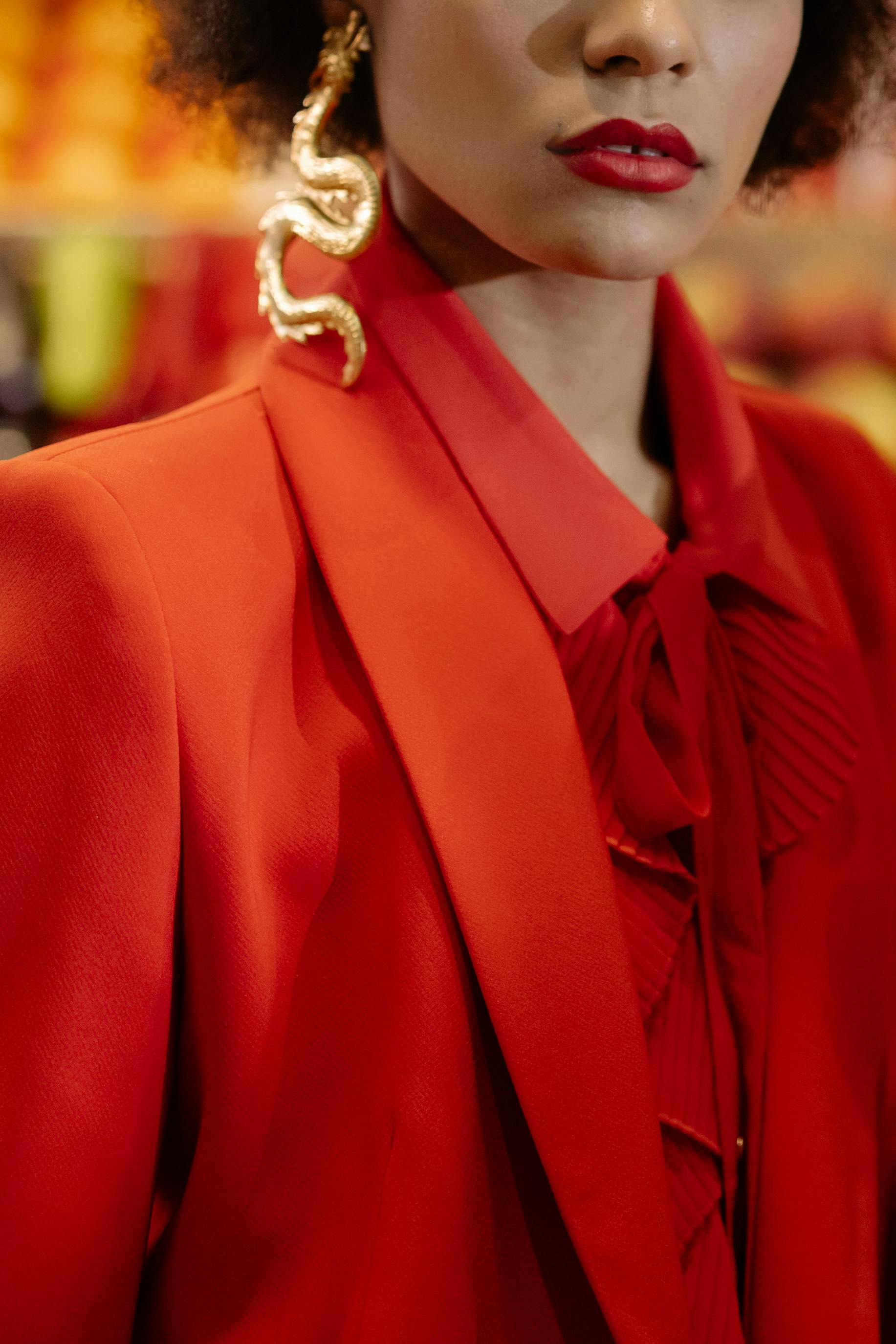 woman in red blazer wearing gold snake earring