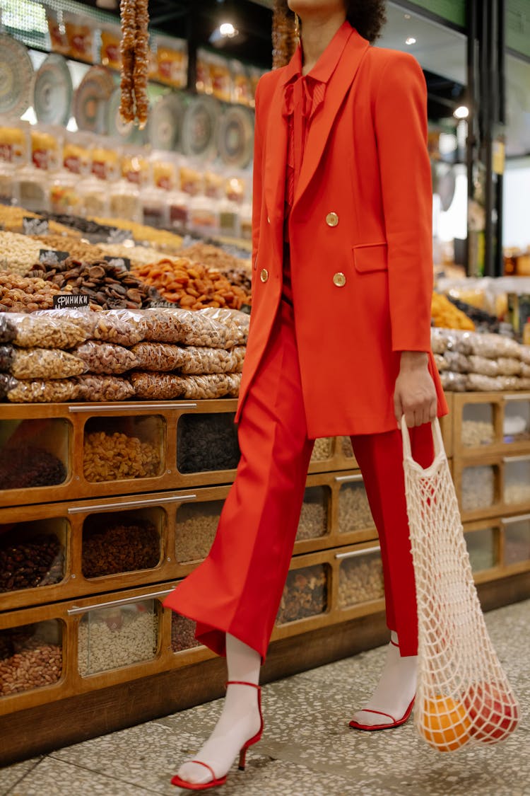 Woman Walking In The Supermarket Holding A Net Bag