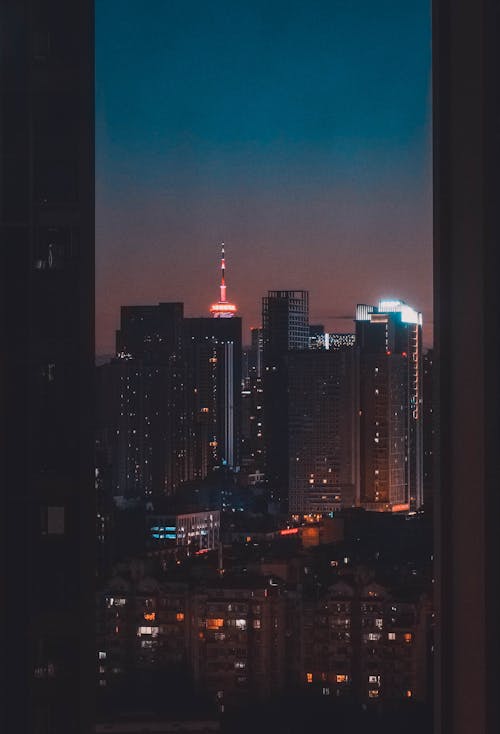 Free Window View of High Rise Buildings During Night Time  Stock Photo