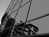 一座现代建筑的倒影映在玻璃窗上，以引人注目的黑白细节被捕捉到