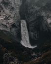 Waterfall flowing out of cave in rocks