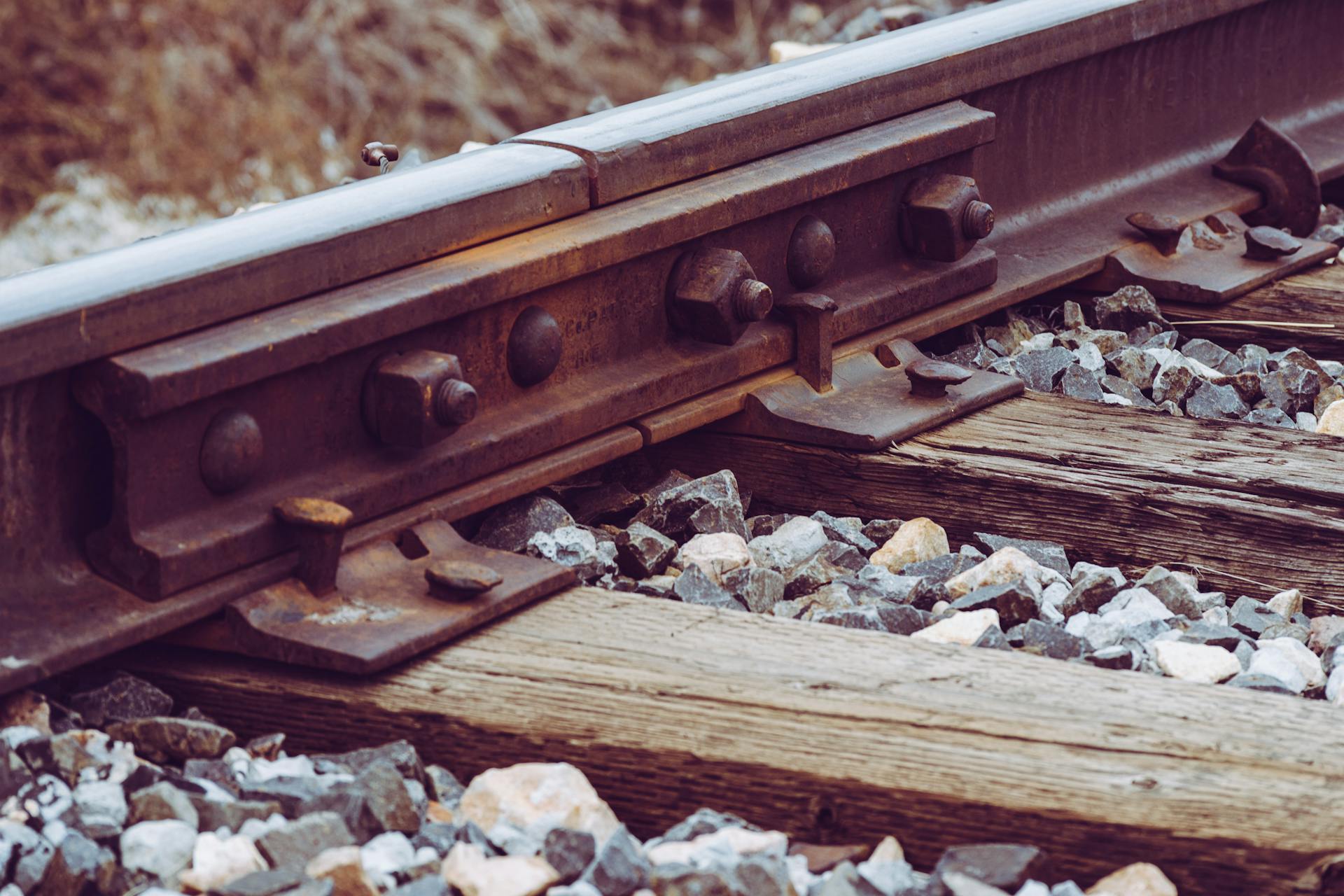 Detailed view of a railway track with wooden sleepers and gravel ballast.