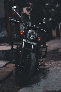Vertical photo of a parked motorcycle on a street, moody lighting.