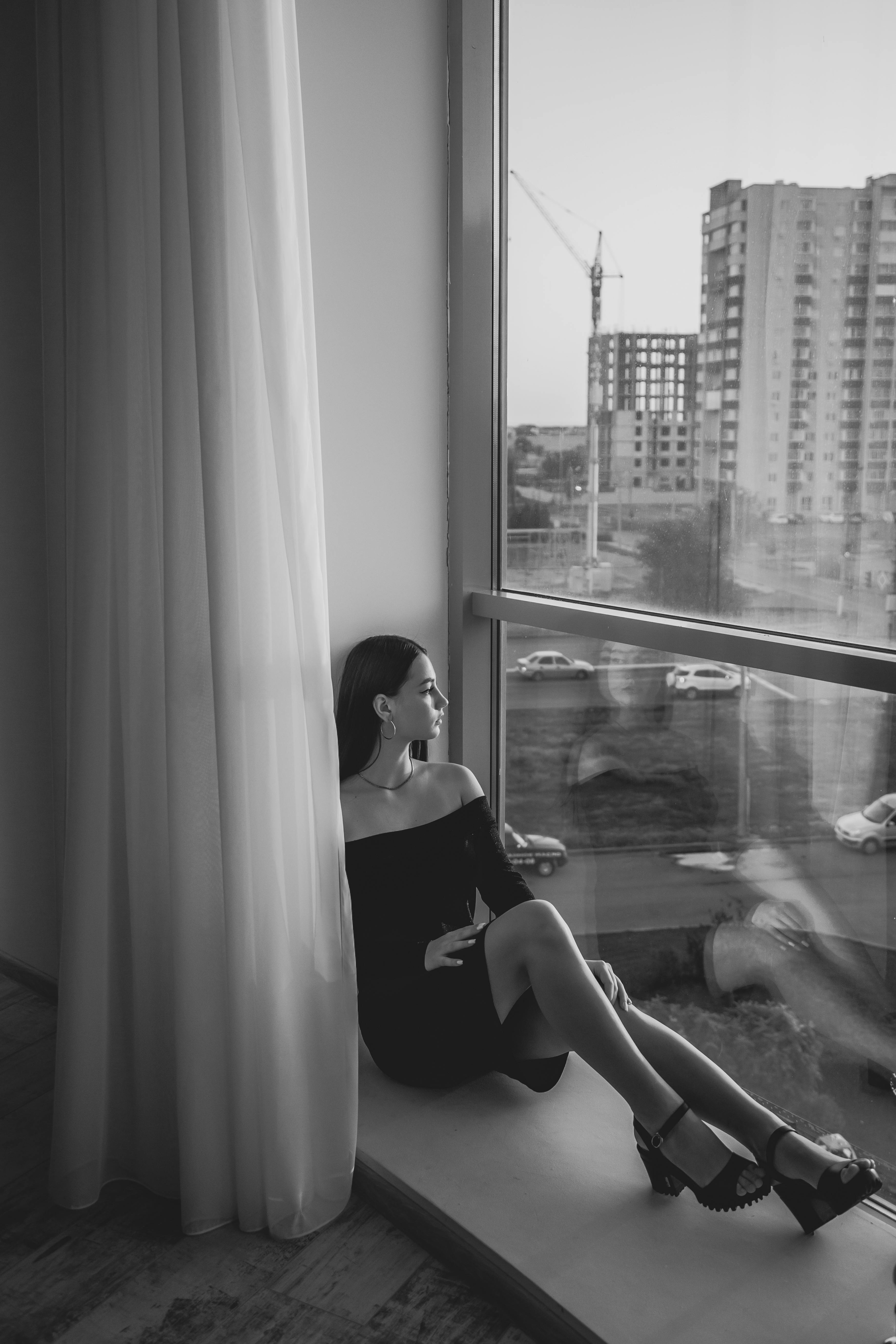 young woman wearing formal outfit sitting on floor by window