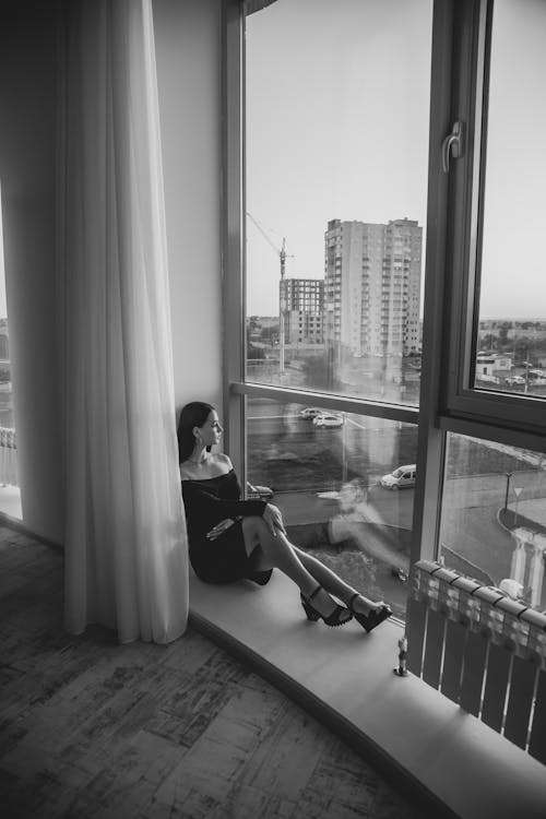 A Woman Sitting Beside the Window
