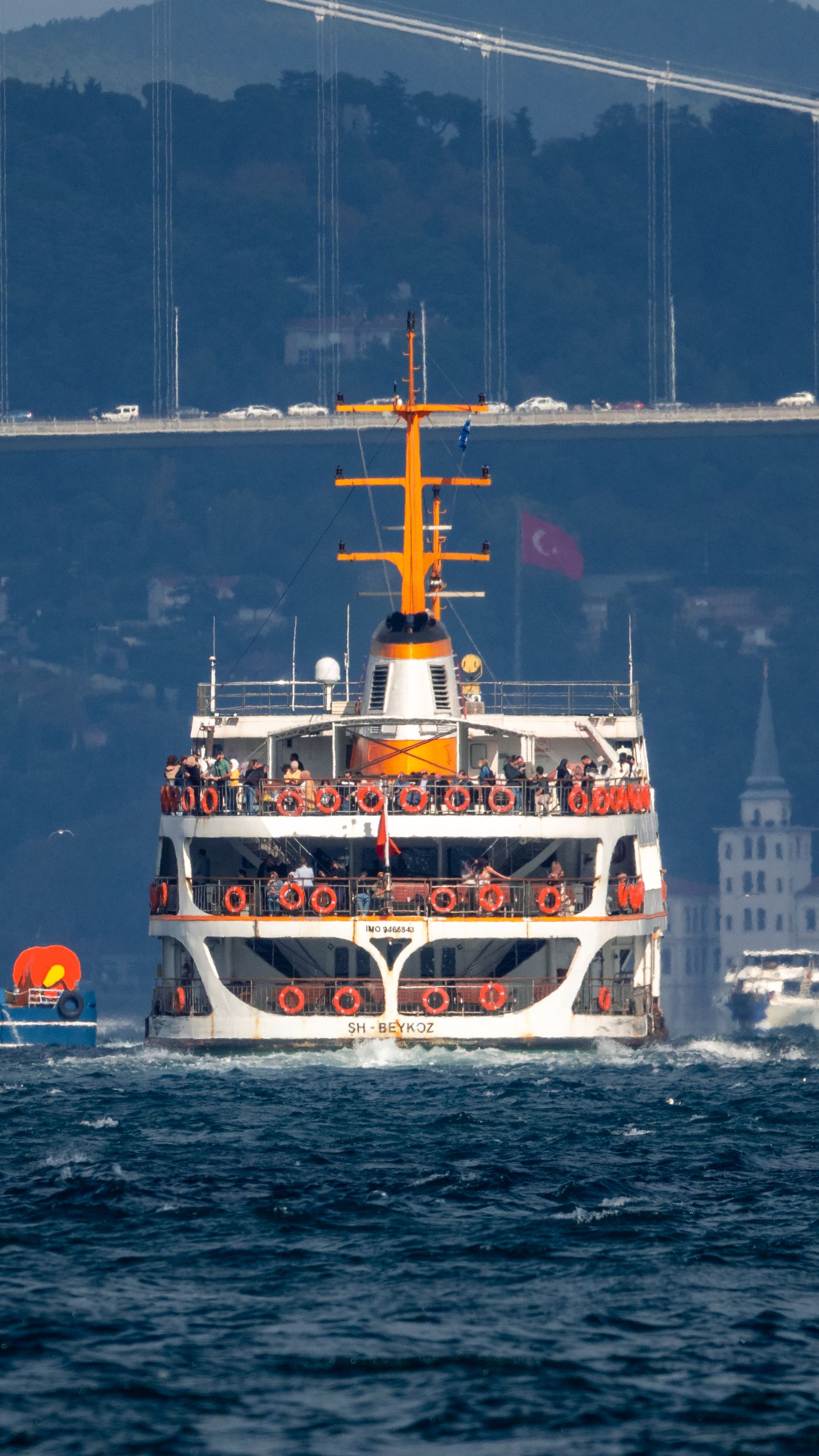 A passenger ferry sails on the Bosporus Strait with Istanbul's landmarks in view.