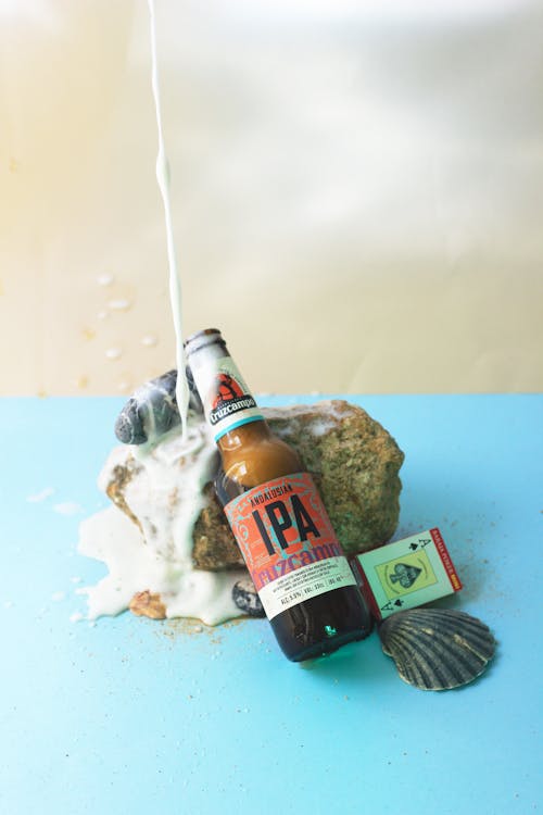 Photo of a Rock Beside a Bottle of Beer