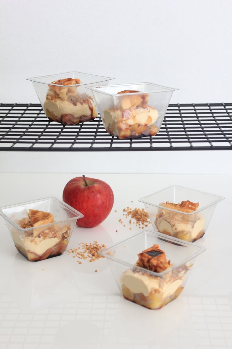 An Apple Near Parfait In Plastic Containers