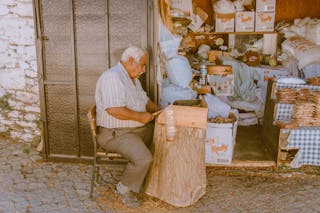 Eldery Man Using Hammer on the Pavement outside his House