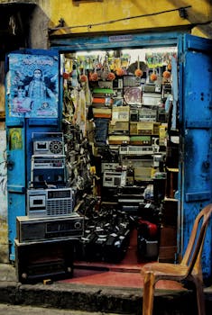 A vintage radio shop with electronics displayed in a cluttered storefront with vibrant blue doors.