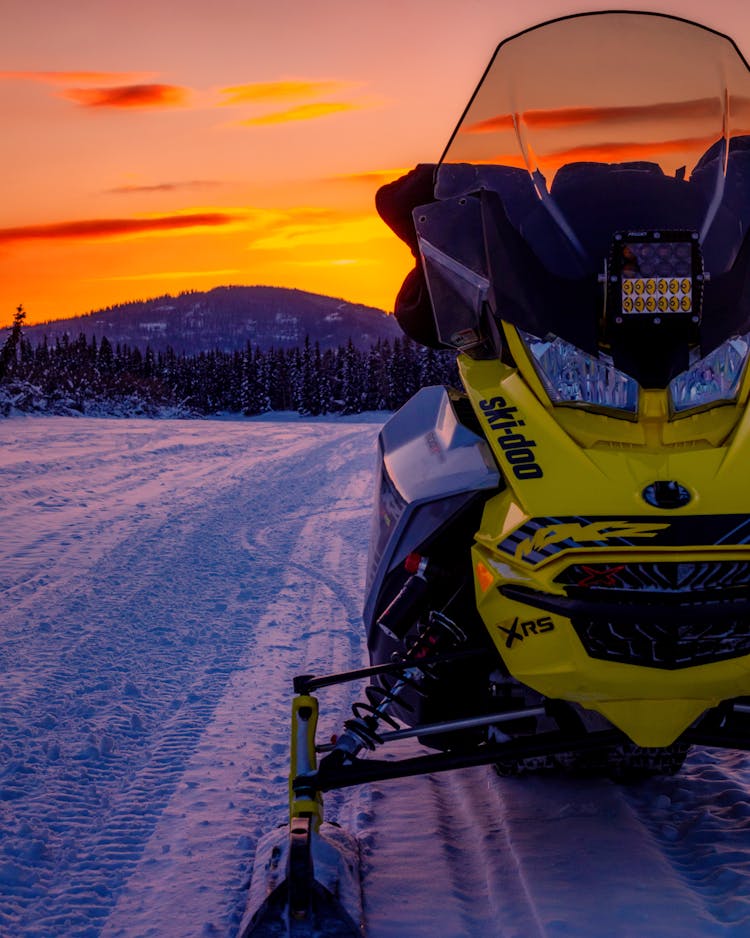 Snowmobile On Hill On Sunset