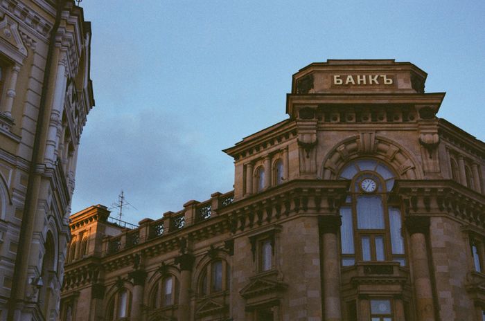 The stone facade of a historic bank building at dusk — photo by Илья Иванов on Pexels