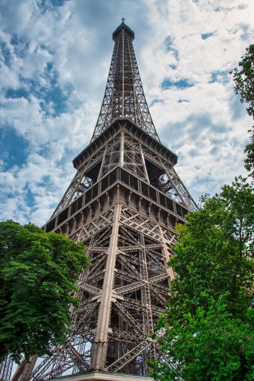 Free Low angle shot of the Eiffel Tower amid trees in Paris, France. Stock Photo