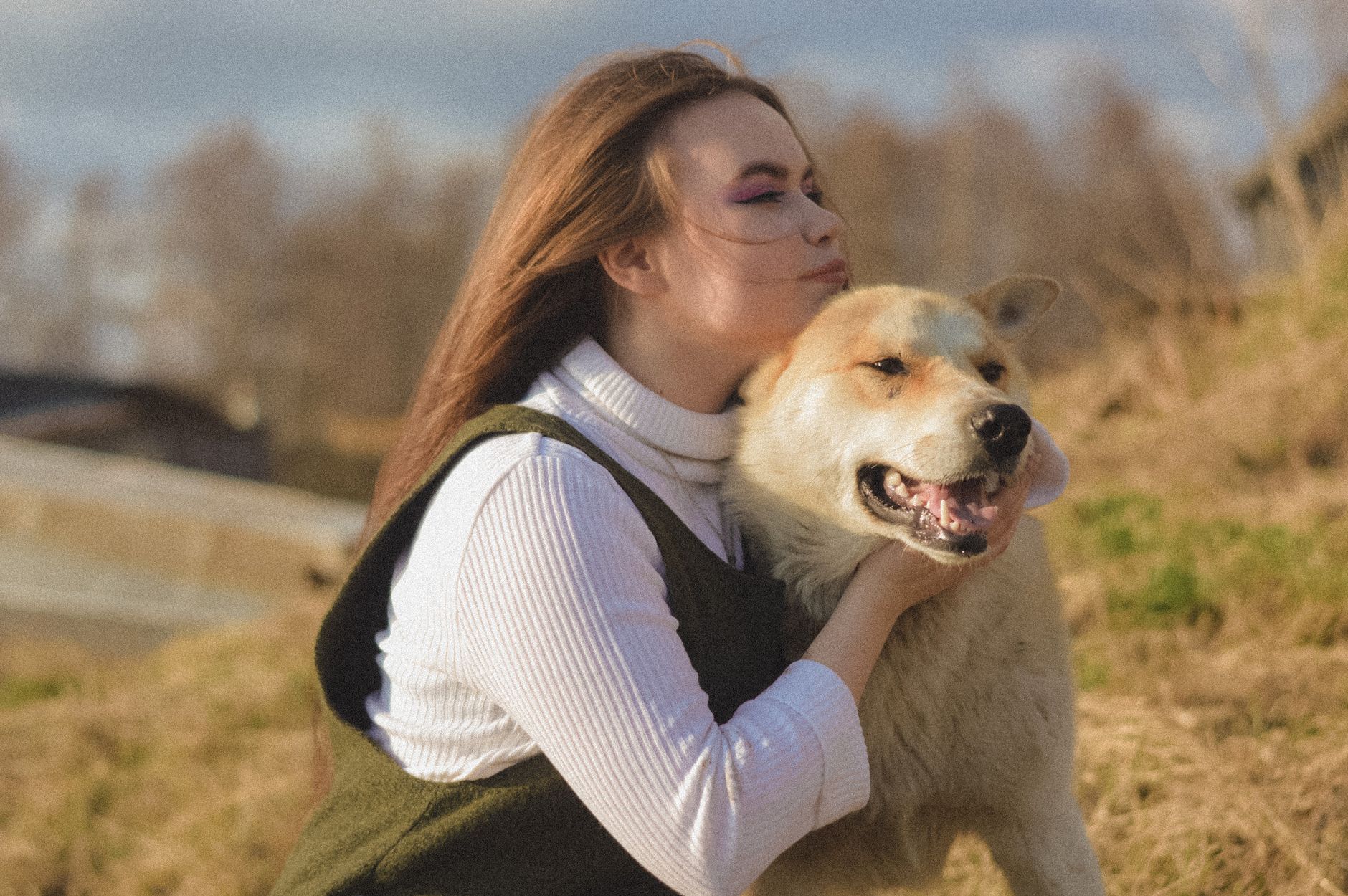 Jeune femme câlinant tendrement son chien dans un pré ensoleillé
