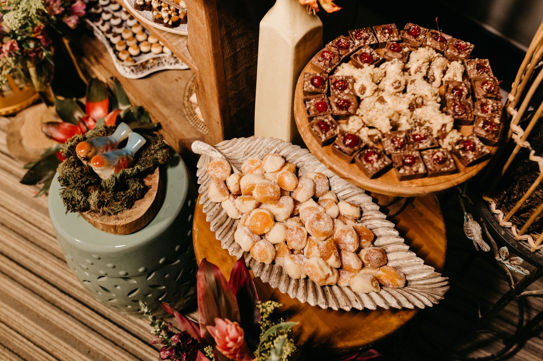 Aesthetic arrangement of assorted sweets and ornate decor on a rustic wooden table.