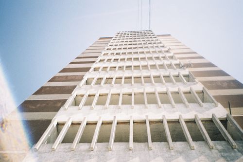 Free A striking low angle shot of a modern multi-storey concrete building in an urban setting. Stock Photo