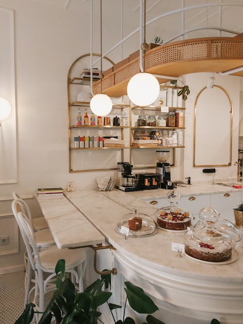 Marble Dining Table With Cakes and Lamps Above