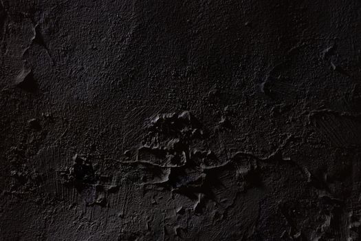 Close-up of a dark textured concrete surface, revealing intricate details and patterns.