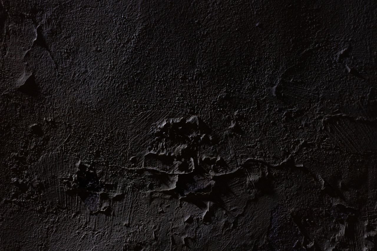 close up of a dark textured concrete surface revealing intricate detai