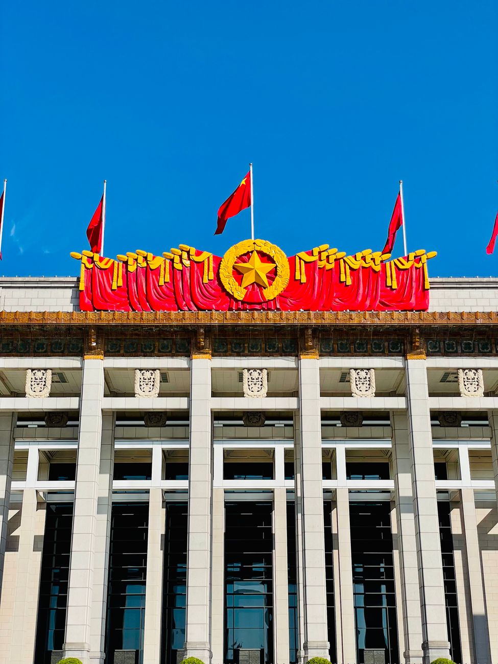 National Museum of China facade with red flags under a blue sky in Beijing