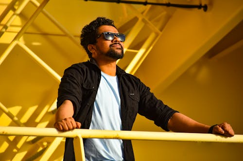 Portrait of standing man with beard and sunglasses looking up