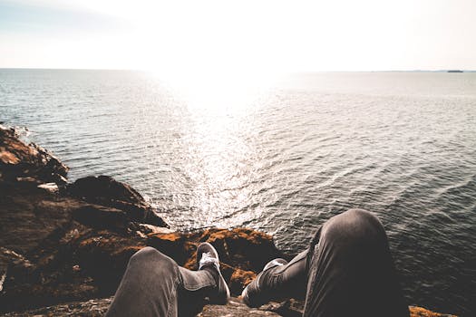 Photo of Person Sitting on Cliff