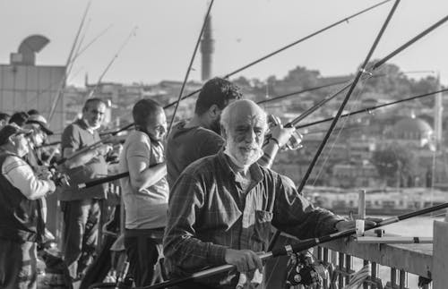 Grayscale Photo of an Elderly Man Fishing