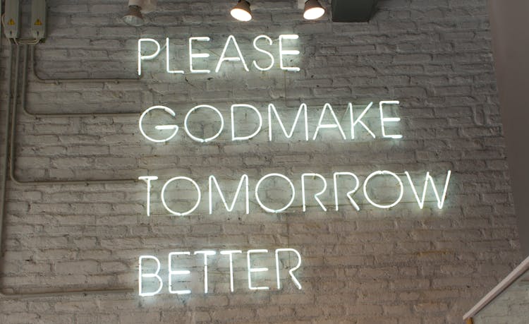 Illuminated Signage On Brick Wall