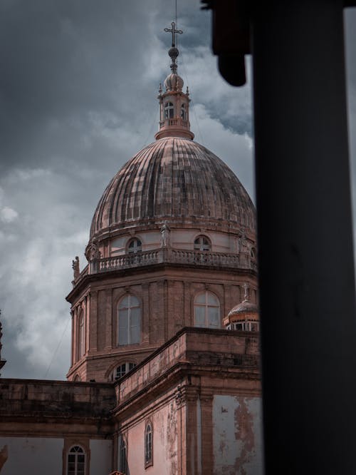 Brown Concrete Dome Building Under Cloudy Sky