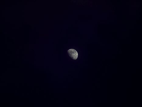 Beautiful half moon captured against a dark night sky with ample copy space.