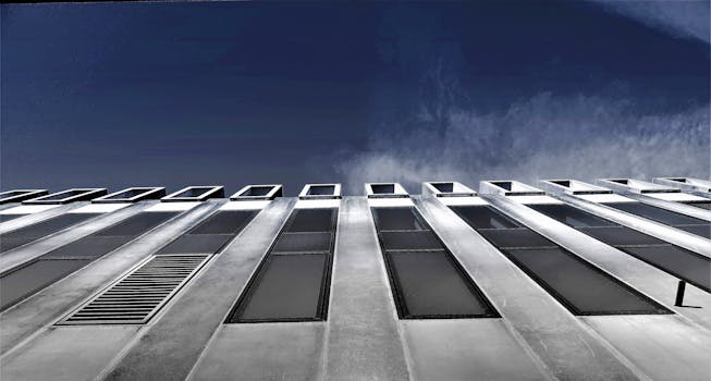 玻璃窗映衬着清澈蓝天的现代建筑立面低角度视图