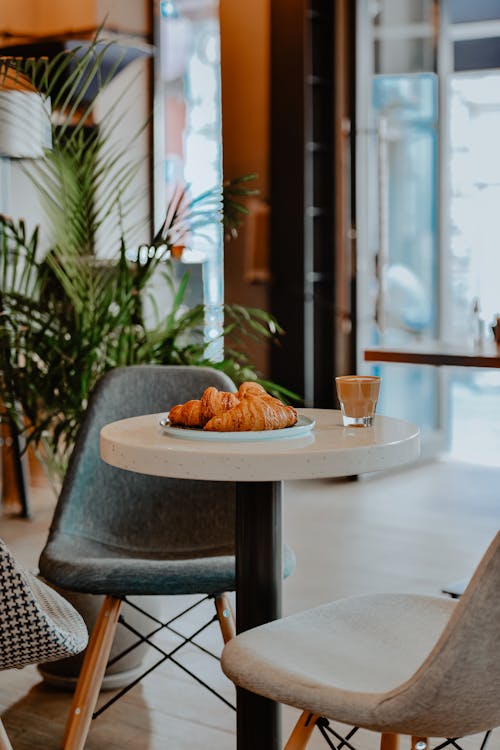 Free A croissant and coffee in a glass at cafe Stock Photo