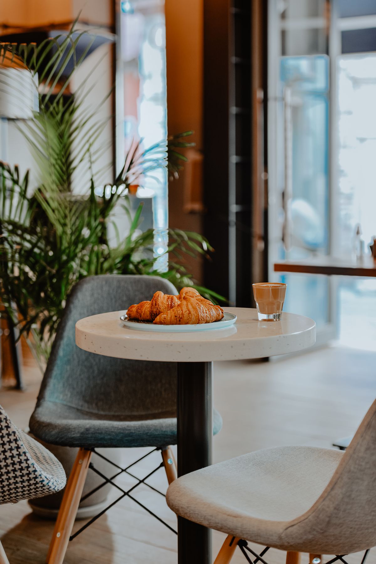 Cafea și croissant într-o cafenea luminoasă