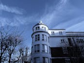 一座白色建筑引人注目，它有一座弧形塔楼，映衬在清澈的蓝天下