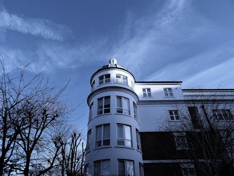 一座白色建筑引人注目，它有一座弧形塔楼，映衬在清澈的蓝天下