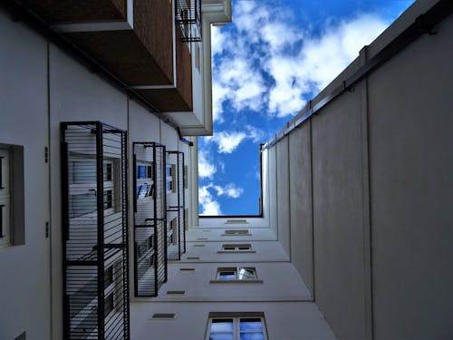 免費 白天在藍天下的灰色混凝土建築的低角度攝影 圖庫相片