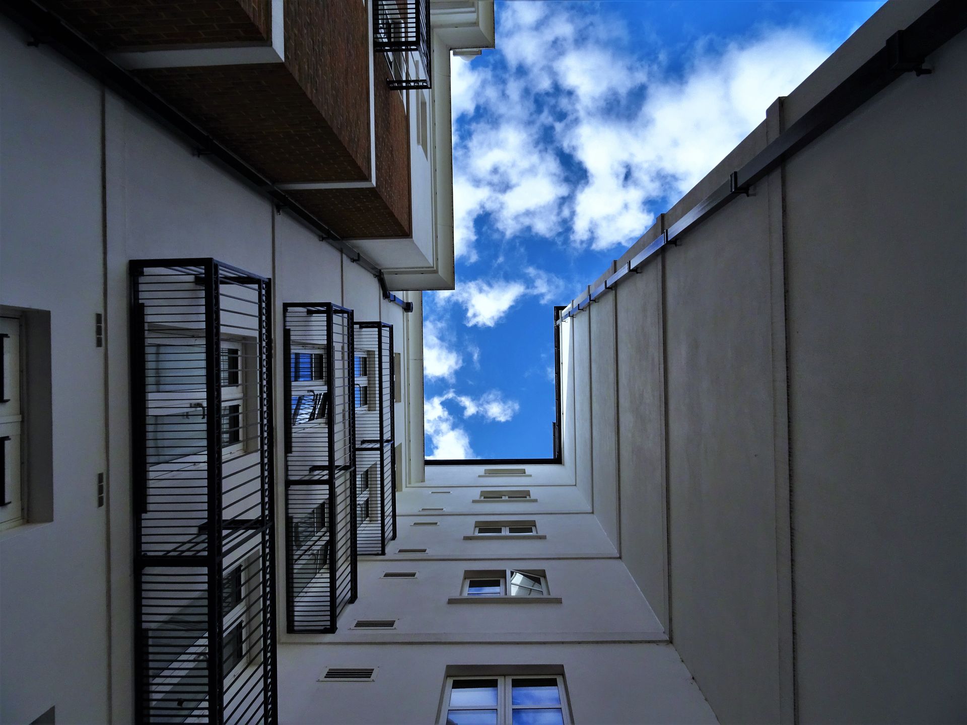 Urban architecture with balconies and a vibrant blue sky, showcasing contemporary exterior design.