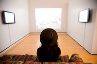 Woman Sitting on Red-and-green Suede Sofa Facing Well Lighted Room